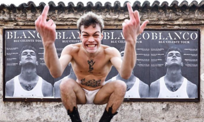 Il cantante Blanco davanti agli striscioni del concerto
