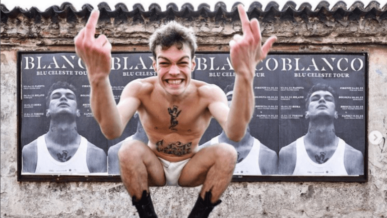 Il cantante Blanco davanti agli striscioni del concerto
